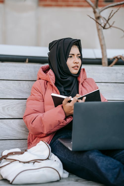Free Lady studying on computer and notepad in park Stock Photo
