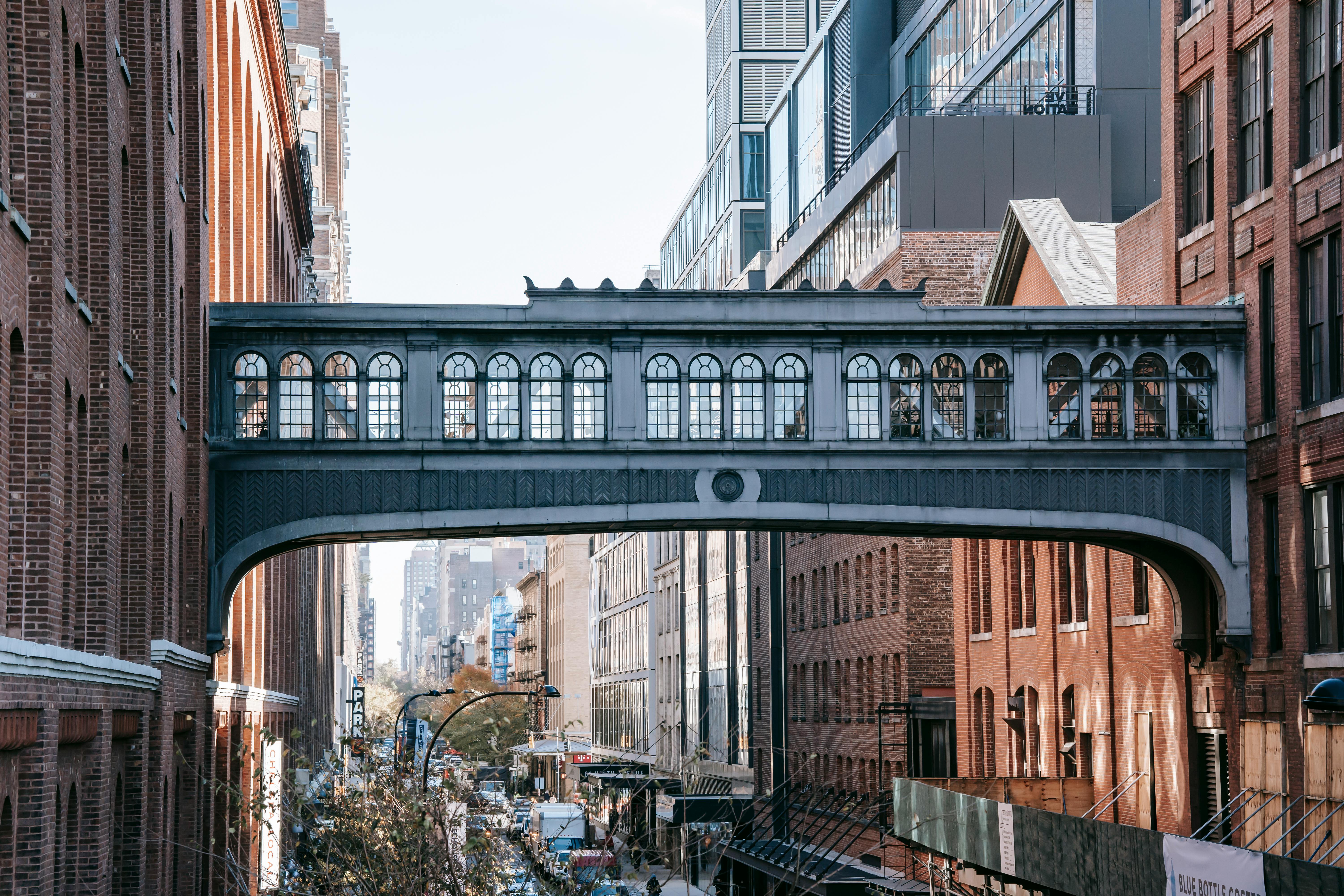 modern bridge between brick buildings on street