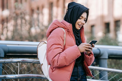 Donna In Hijab Nero E Giacca Rosa Che Tiene Smartphone