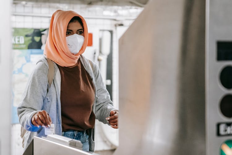 Muslim Female In Mask Going Through Turnstile