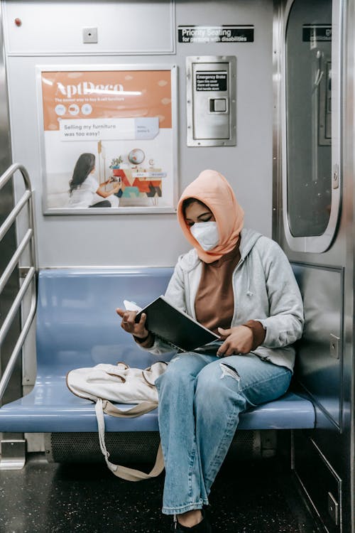 Mulher De Hijab Branco E Jaqueta Cinza Sentada Na Cadeira Branca