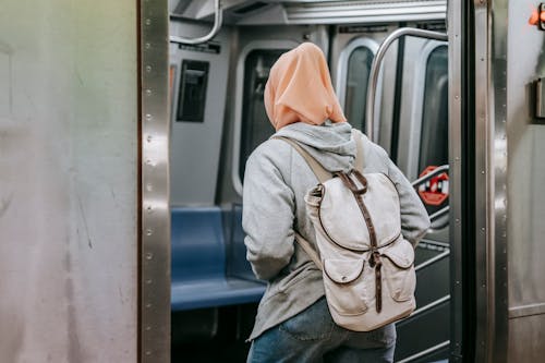 Unrecognizable woman in hijab walking in train in metro