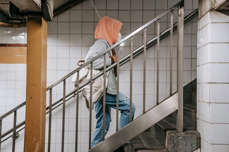 Faceless Ethnic Female Walking In Mask On Steps In Metro