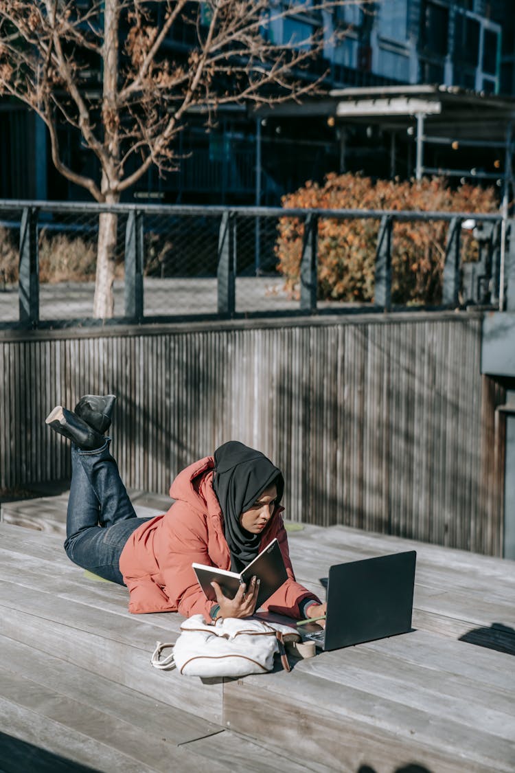 Young Student Working On Project Using Laptop Lying On Roof