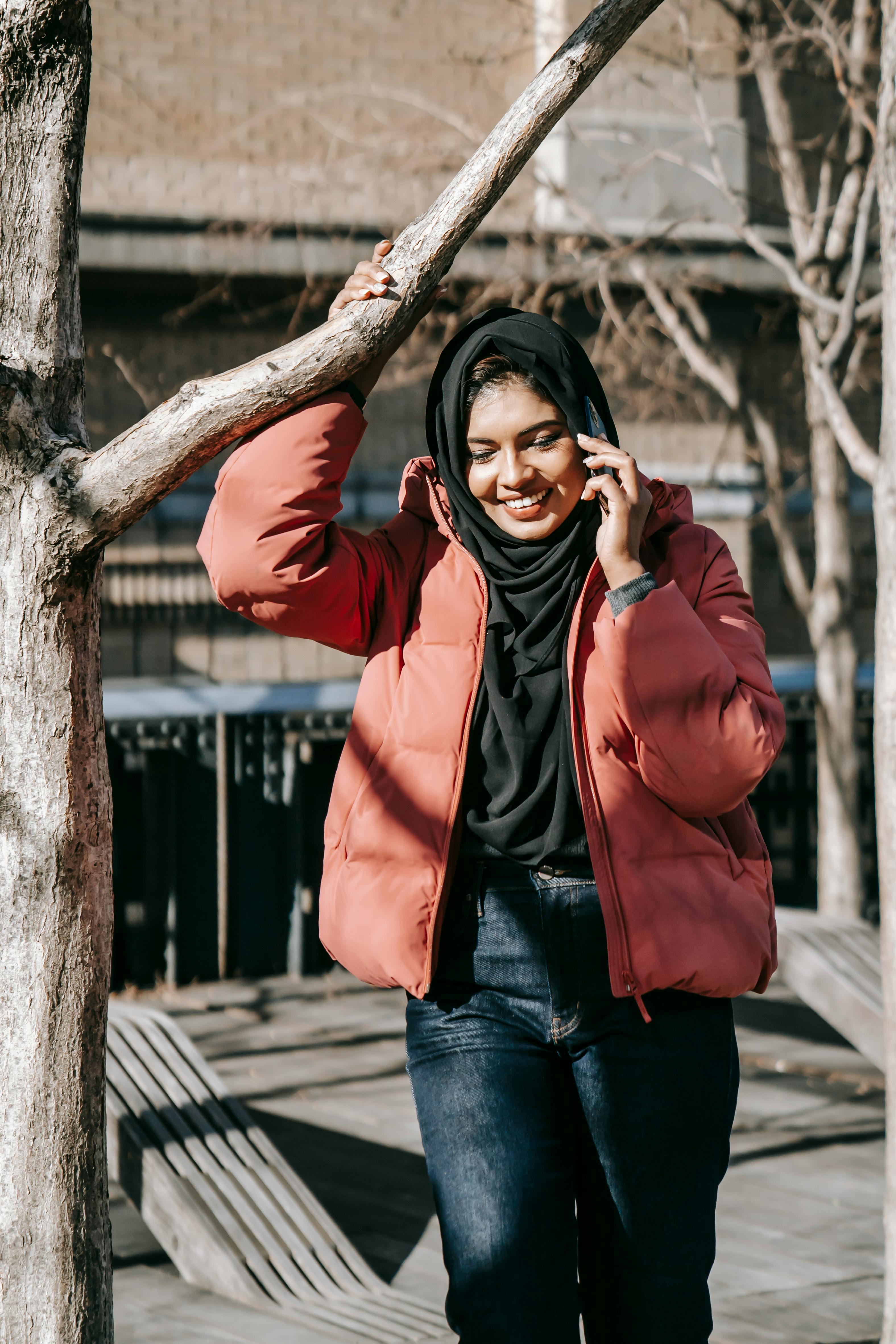 cheerful woman talking on smartphone in park