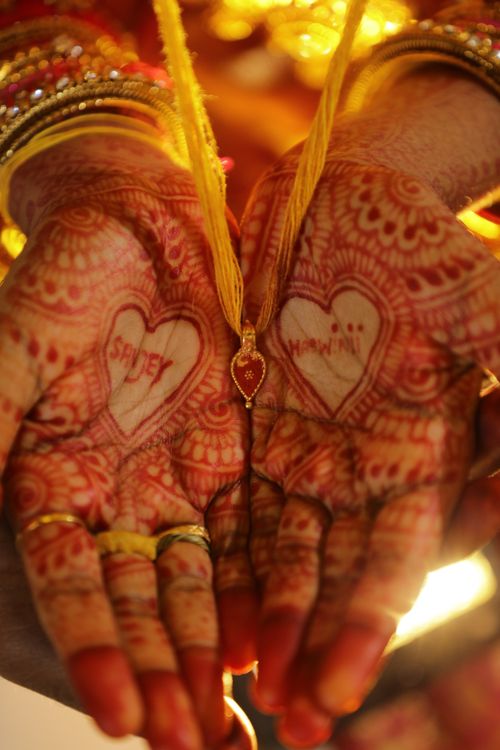 Free Close-up of traditional bridal henna with heart designs on palms, evocative of cultural beauty. Stock Photo