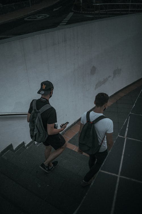 Men Walking on Concrete Stairs