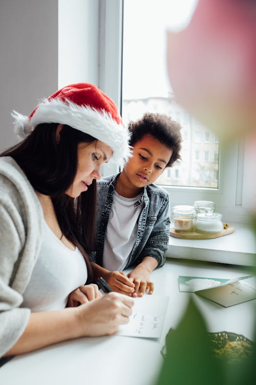 Woman Wearing A Santa Hat Writing A Letter