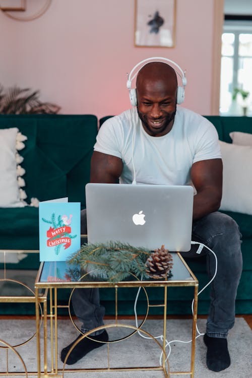 Man In White Crew Neck T-shirt Sitting On A Chair Using Macbook