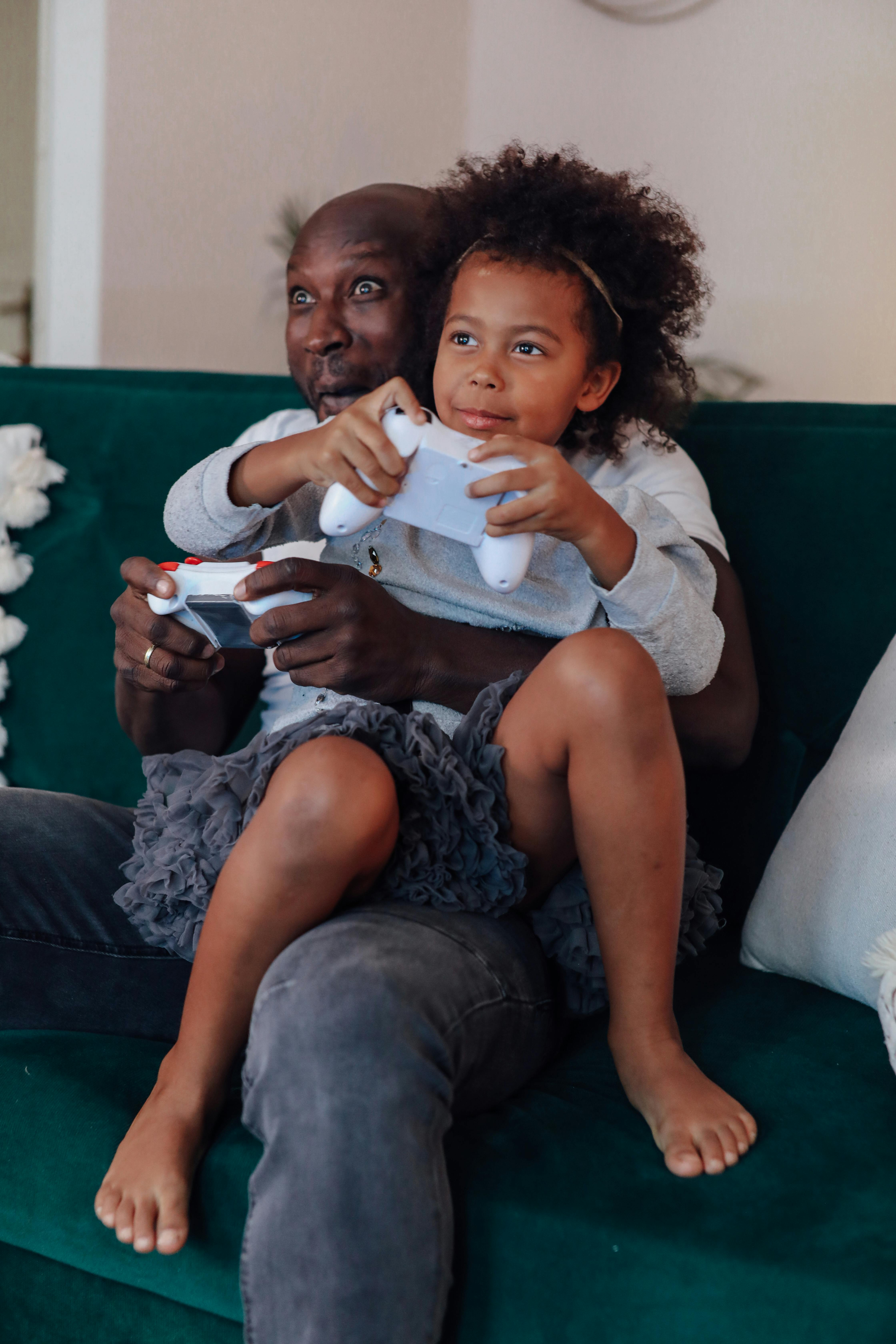 A loving father and daughter enjoying video games together, showcasing family bonding.