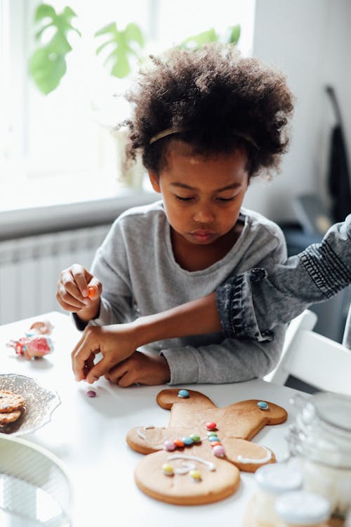 Free Girl In Gray Long Sleeve Shirt Decorating Cookies Stock Photo