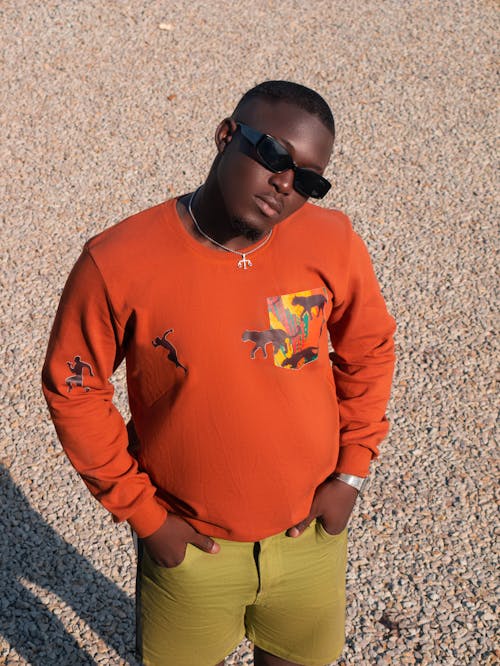 A Man Wearing an Orange Sweater and a Pair of Sunglasses