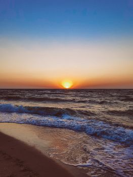 Breathtaking sunset over the Black Sea shoreline in Odessa, Ukraine with gentle waves and warm colors.