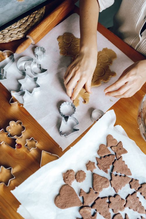 Free Hands cutting festive shaped cookies, capturing the joy of holiday baking. Stock Photo
