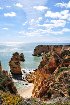 Stunning rock formations along Algarve's coastline under a clear blue sky.