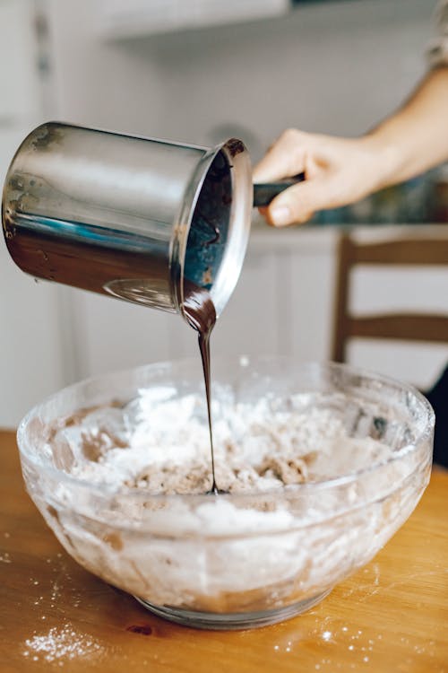 Free A Person Pouring Melted Chocolate on Glass Bowl Stock Photo