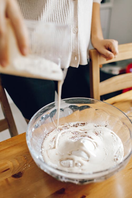 Free A Person Pouring Milk on a Bowl of Flour Stock Photo