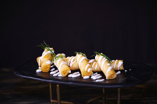 Fried Spring Rolls with White Cream and Green Leaves