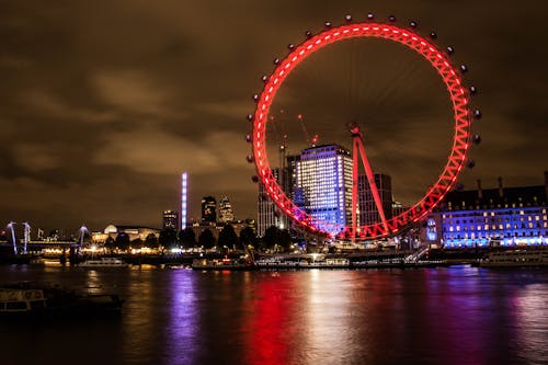 Free Red Lighted Ferris Wheel Near Body of Water During Night Time Stock Photo