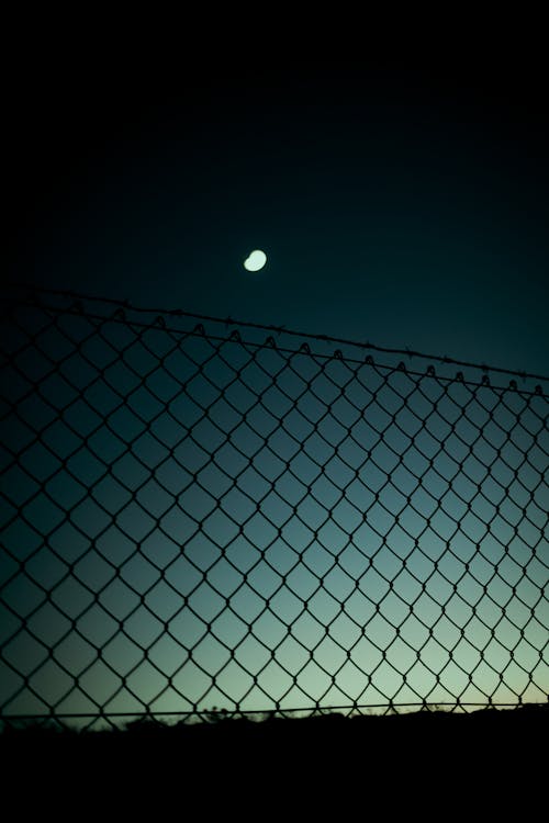 Free Metal Fence Under The Moonlight Of Dark Night Sky Stock Photo
