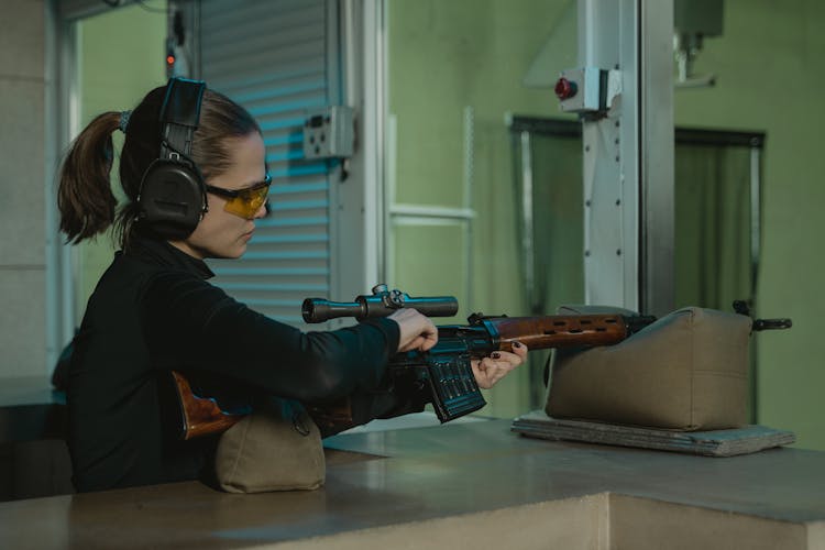 A Woman Holding A Sniper Rifle