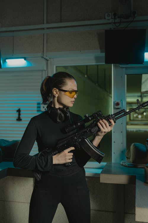 Woman in Black Long Sleeves Holding a Rifle