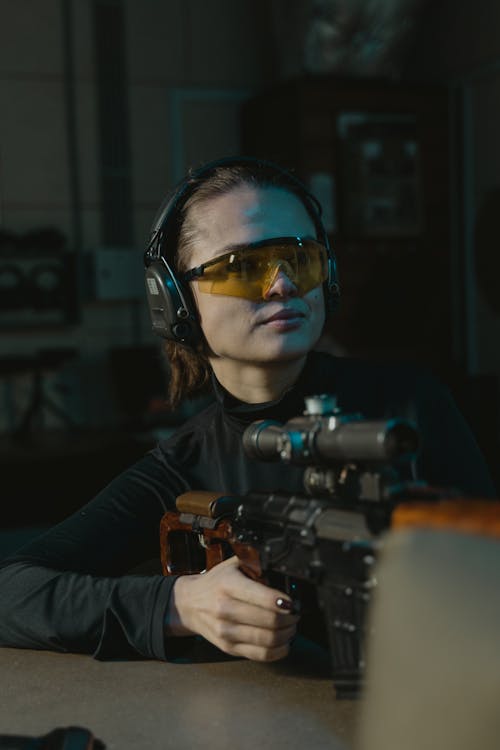 Woman in Black Long Sleeves Holding a Rifle