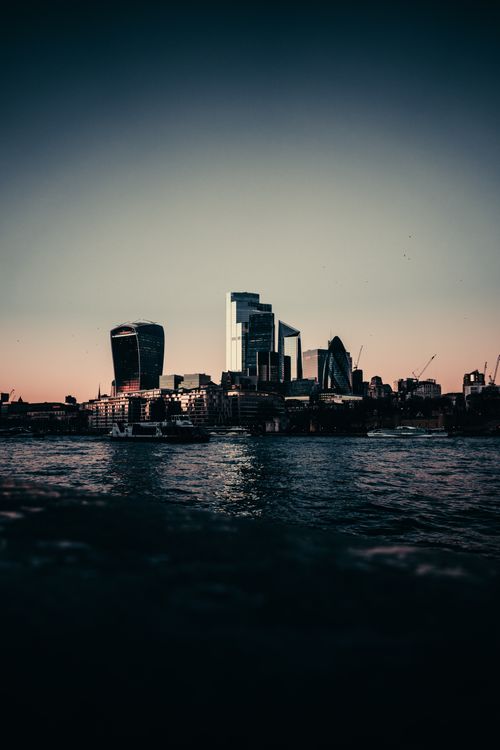 Free A stunning view of London's skyline at sunset, featuring modern skyscrapers reflecting on the Thames. Stock Photo