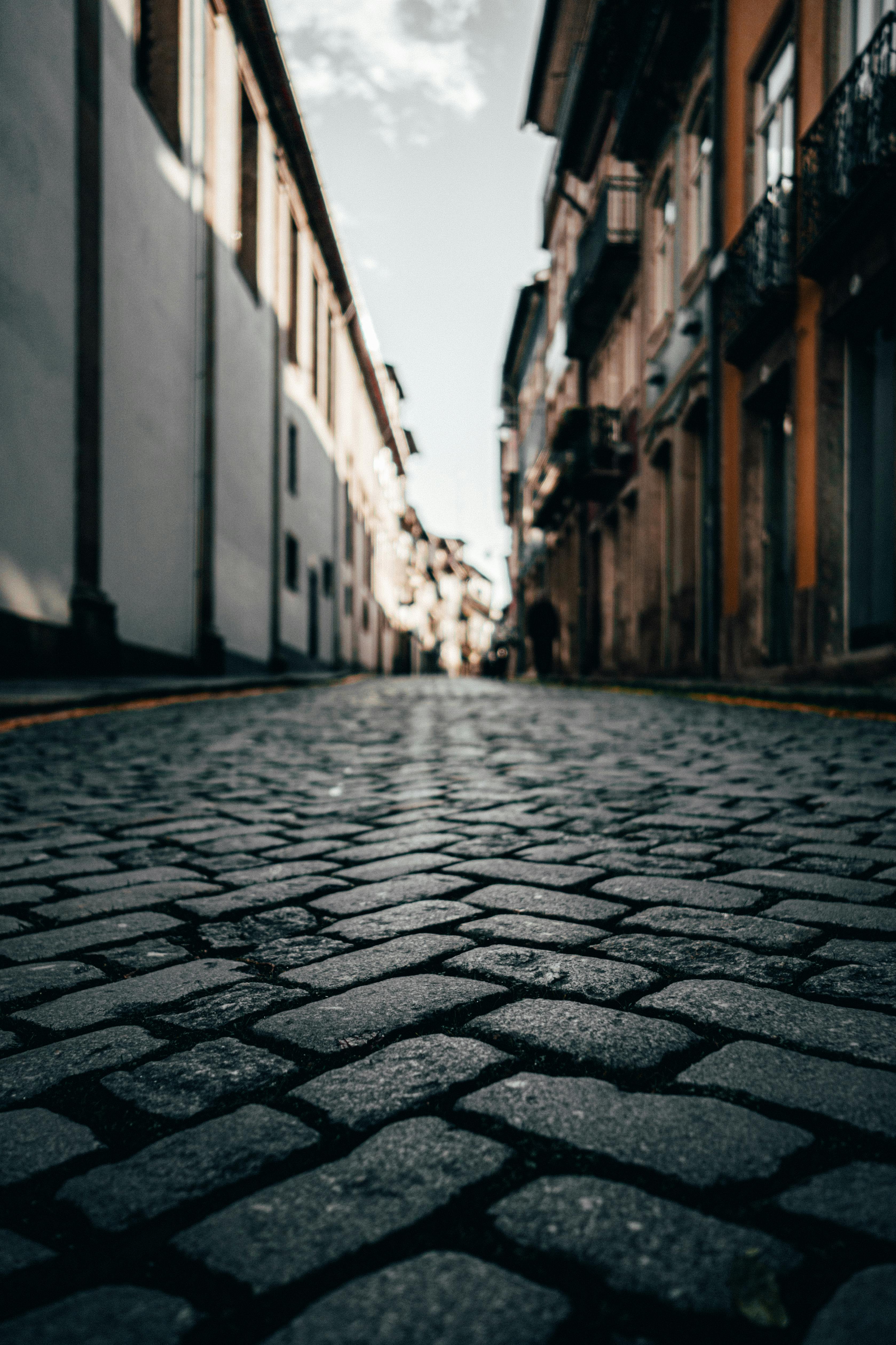 A low-angle view of cobblestone streets lining a historic city's architecture.