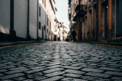 A low-angle view of cobblestone streets lining a historic city's architecture.
