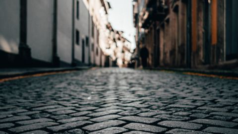 A low-angle view of cobblestone streets lining a historic city's architecture.
