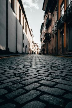A low-angle view of cobblestone streets lining a historic city's architecture.
