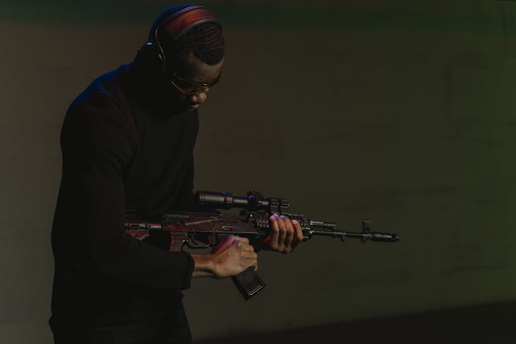 Man Near A Concrete Wall Holding Rifle