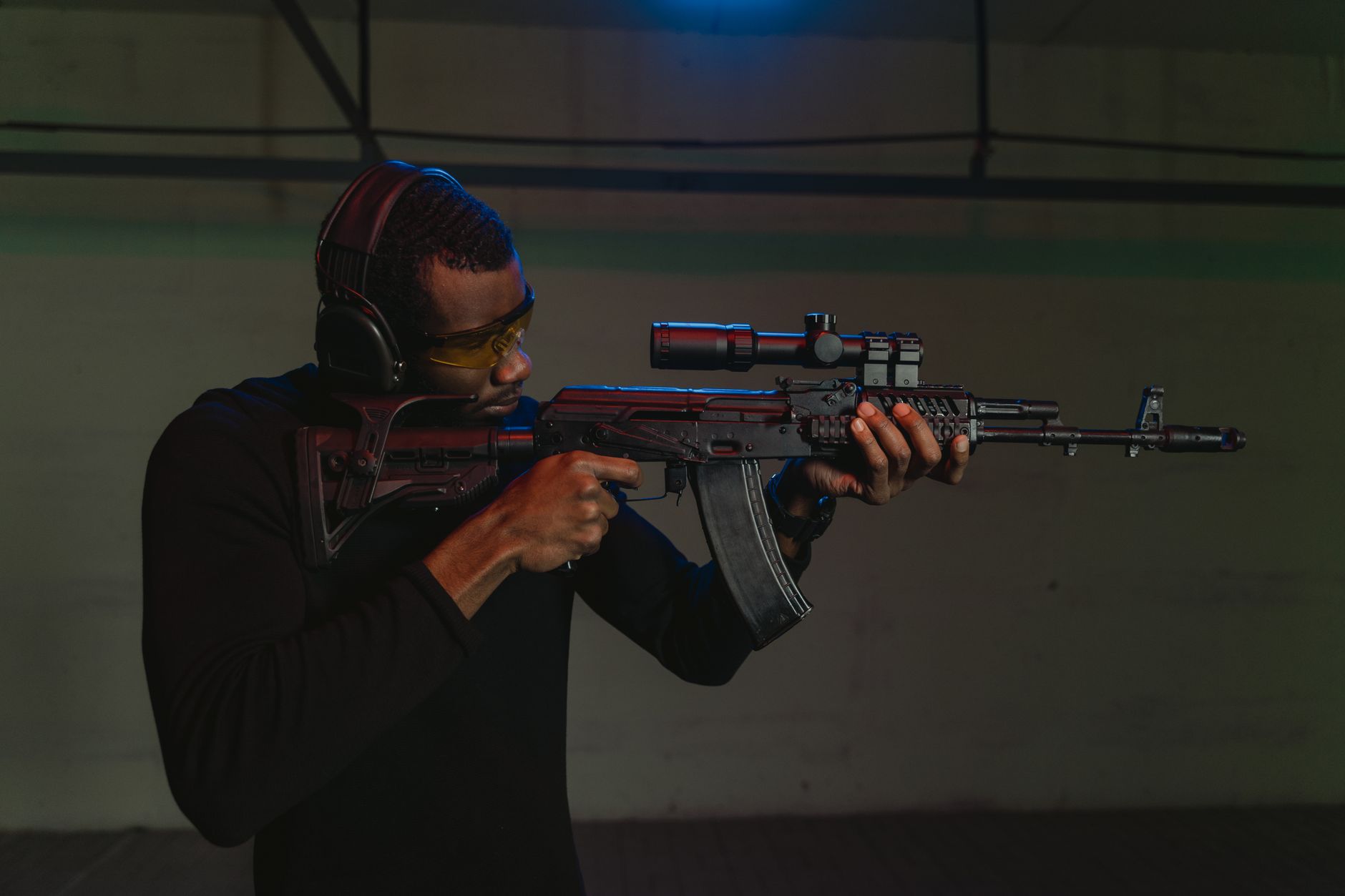 Atış poligonunda AK-47 ile poz veren bir kişi