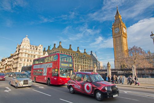 Free A vibrant scene of London with buses, taxis, and iconic Big Ben amidst urban life. Stock Photo