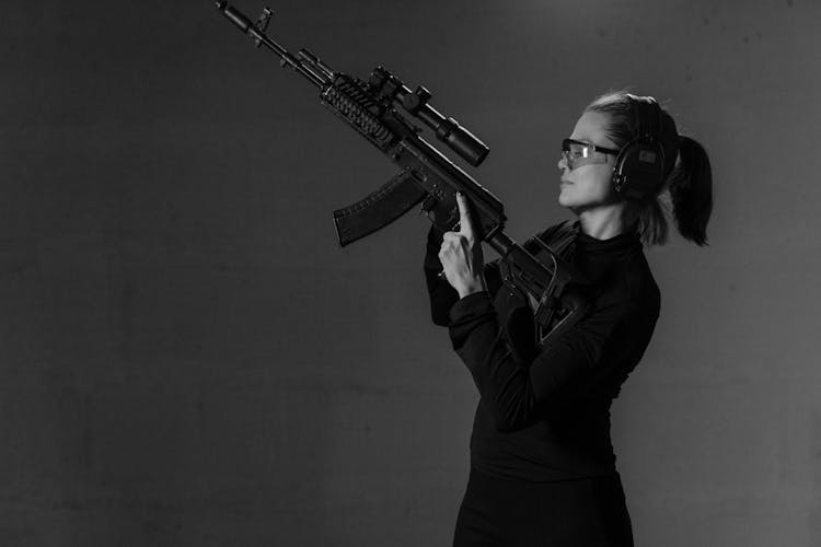 Grayscale Photo Of Brave Woman Holding A Black Sniper Rifle