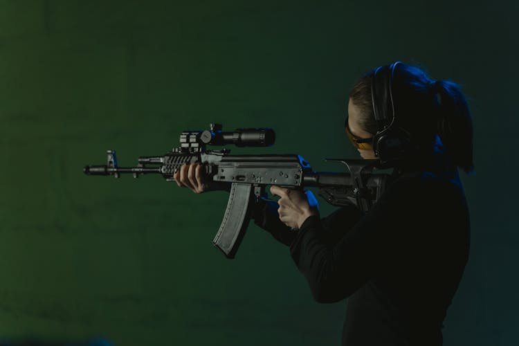 Person Looking At The Target While Holding A Rifle 