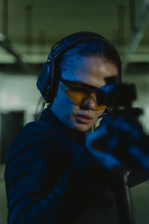 Close-Up Shot of Beautiful Woman Holding a Rifle Aiming for the Target