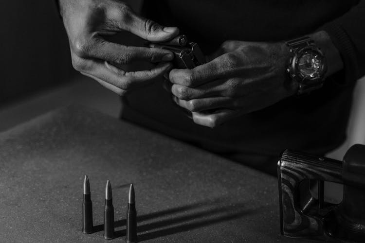 Person Holding A Bullet And A Gun Magazine