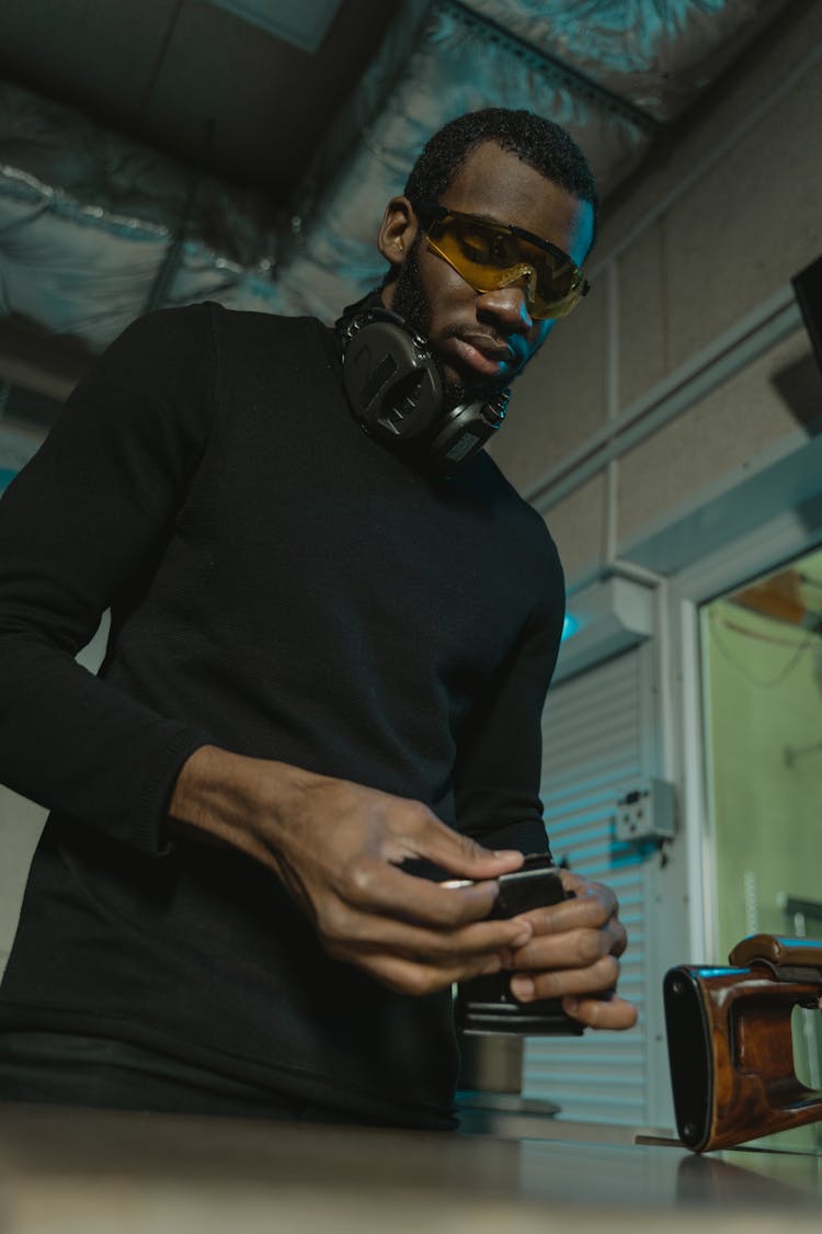 Man With Serious Face Holding A Gun Magazine