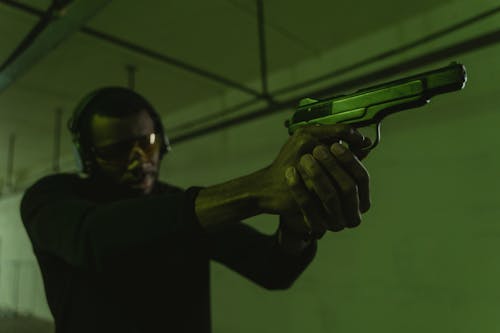 Kostnadsfri bild av afroamerikansk man, handeldvapen, hörselskydd