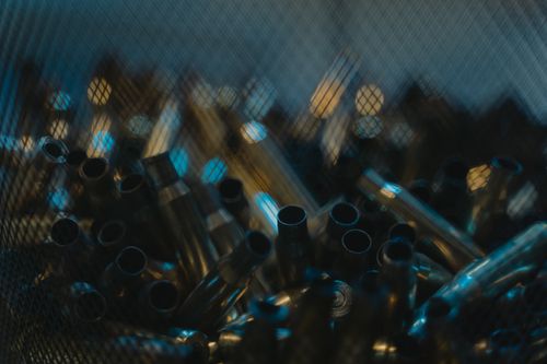 Free Blurred close-up image of bullet casings in a basket with moody lighting. Stock Photo