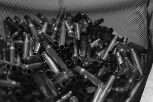 Free Black and white image of spent bullet casings in a container, emphasizing shooting and military themes. Stock Photo