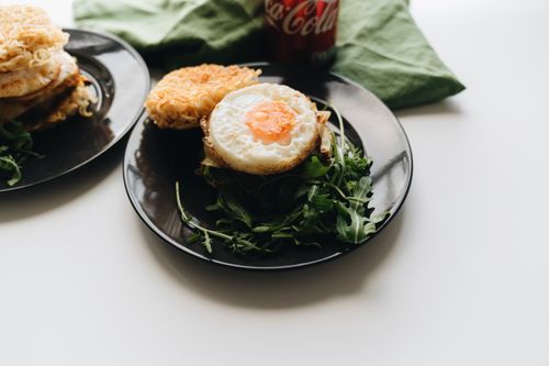 Free Succulent ramen burger topped with a fried egg, served with fresh greens. Stock Photo