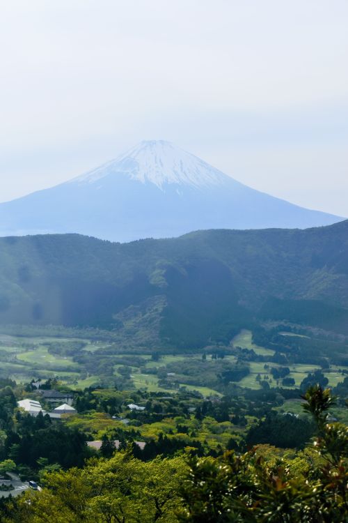 Free Panoramic view of Mount Fuji over Shizuoka's green landscape on a clear day. Stock Photo