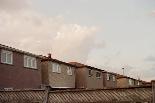 A row of suburban houses beneath a cloudy sky, providing ample copy space.