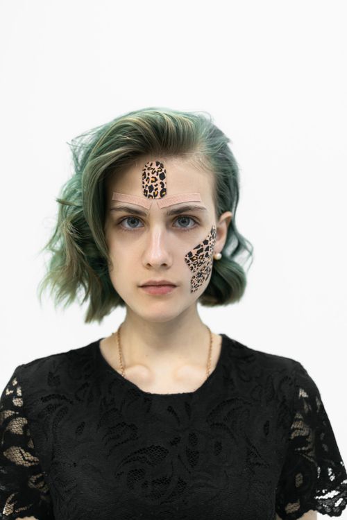 Free Striking portrait of a young woman in black blouse with green hair and leopard print kinesio tapes. Stock Photo