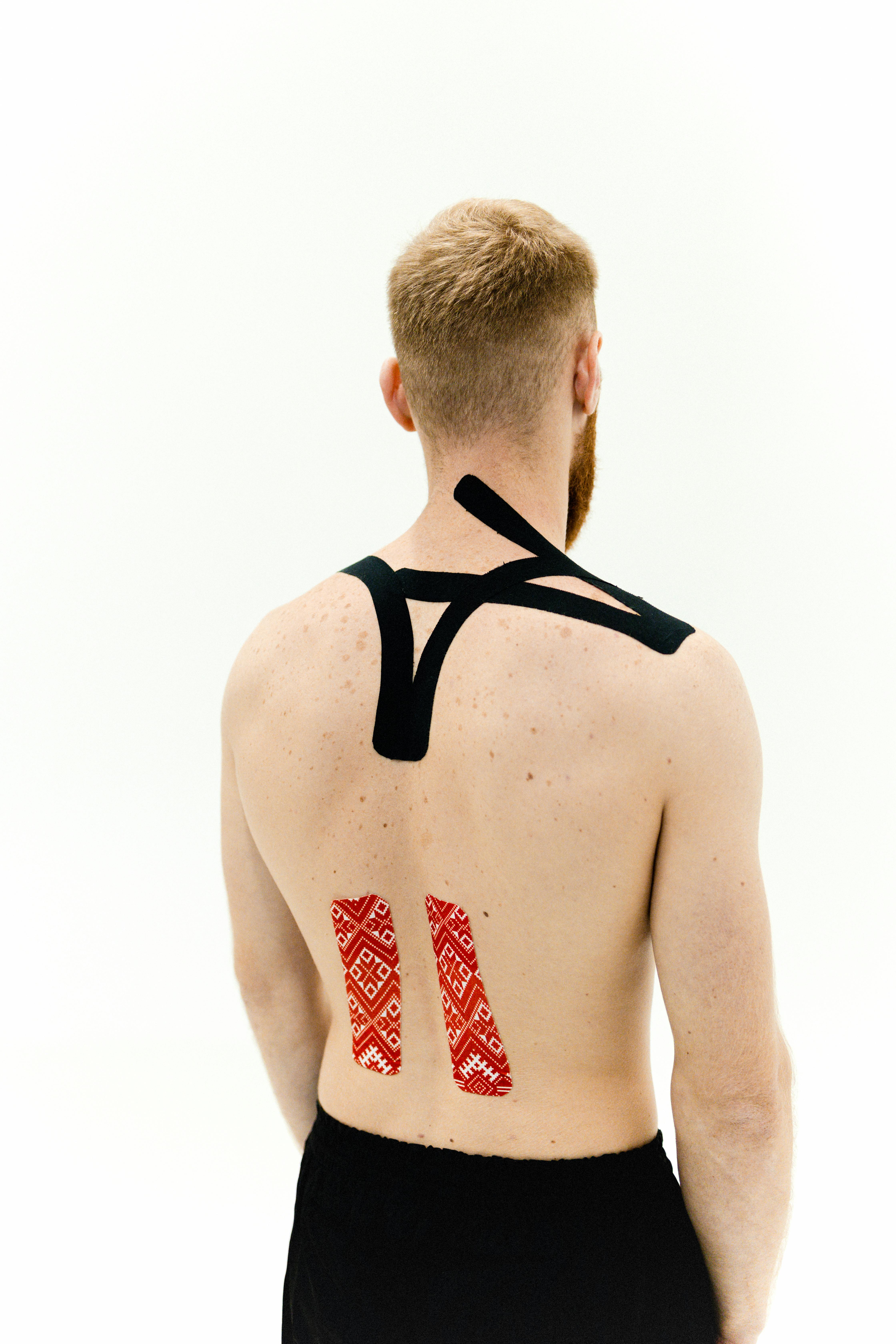 topless man with kinseio tapes on his back