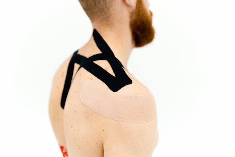 Kinesio Tapes Plastered On A Man's Upper Back And Shoulder