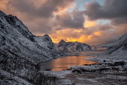 Breathtaking winter sunset over snow-covered mountains and lake in Flakstad, Norway. Moody and majestic scenery.